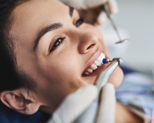 A woman having her teeth cleaned by a dentist.