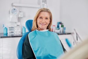 Happy middle-aged woman in dental treatment chair